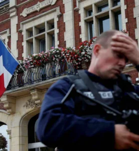 A policeman reacts as he secures a position in front of the city hall after two assailants had taken five people hostage in the church at Saint-Etienne-du -Rouvray near Rouen in Normandy, France, July 26, 2016. REUTERS/Pascal Rossignol