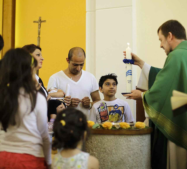 O Pe Gottfried Martens batiza família iraniana em Berlim. Ex-muçulmanos constituem maioria dos 900 paroquianos
