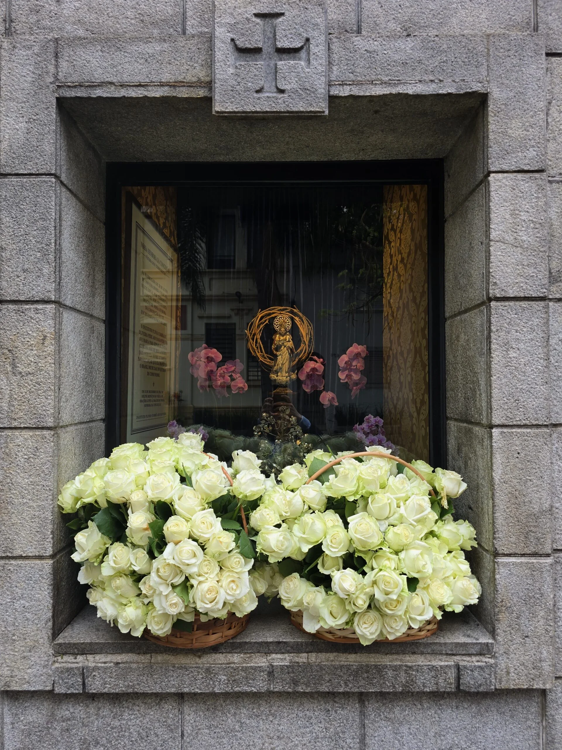 Rosas brancas diante de uma imagem de Nossa Senhora no Oratório