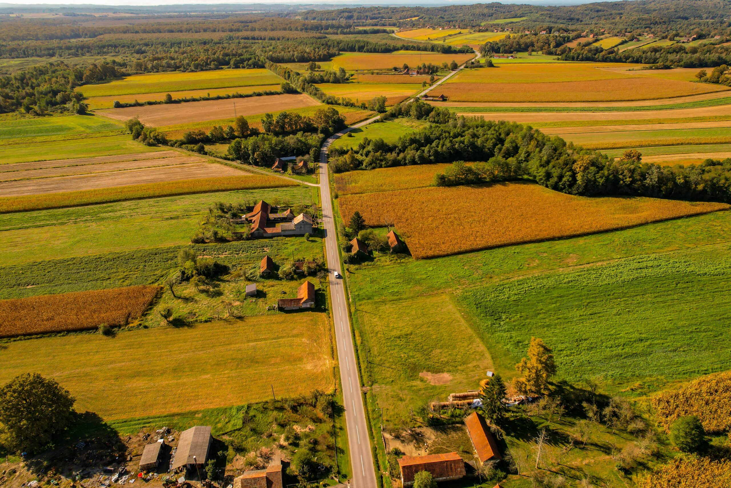 A vibrant aerial view of farmlands and a rural road in Garešnica, Croatia.